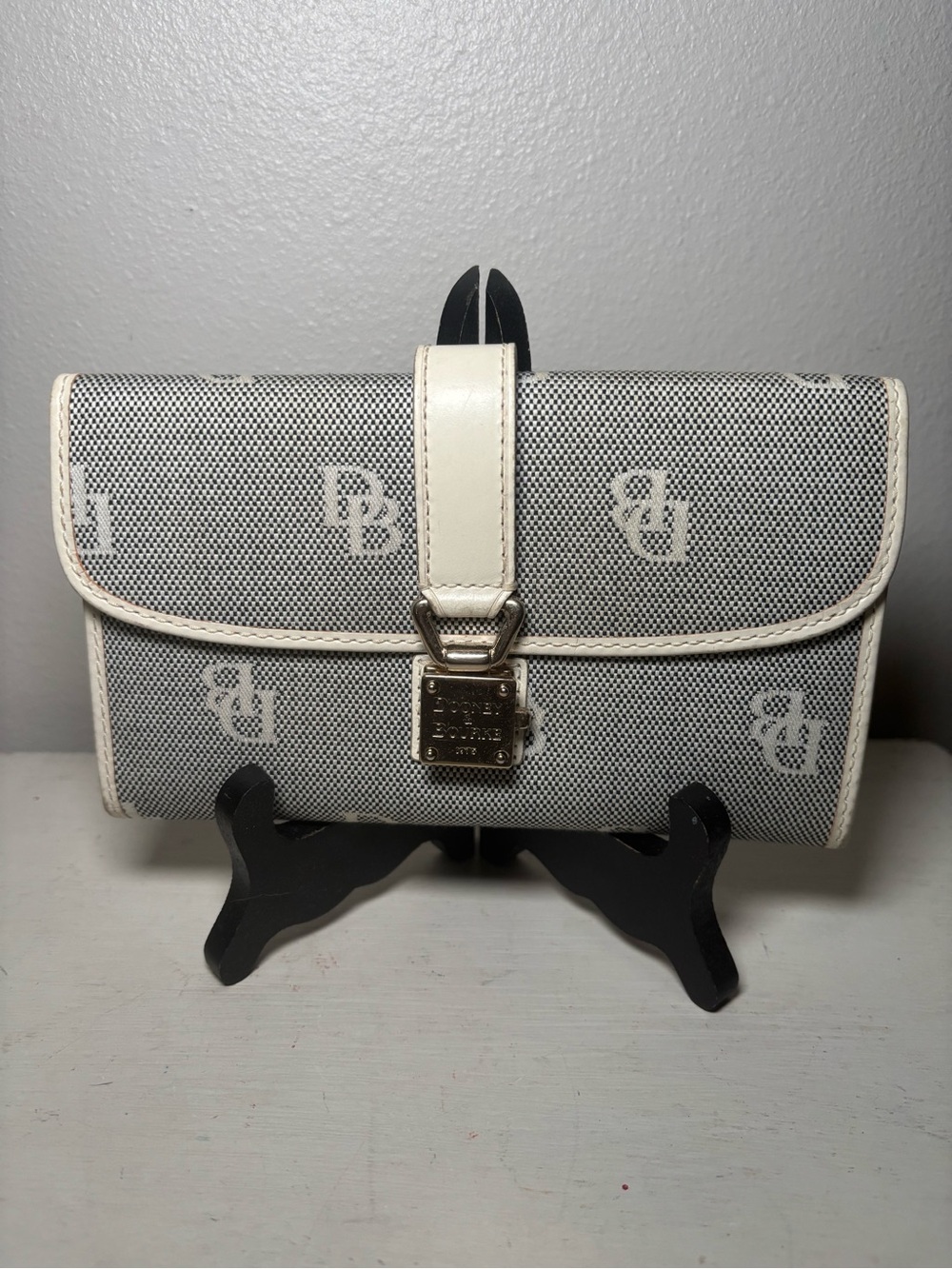 Dooney & Bourke black and white signature monogram lock flap wallet.